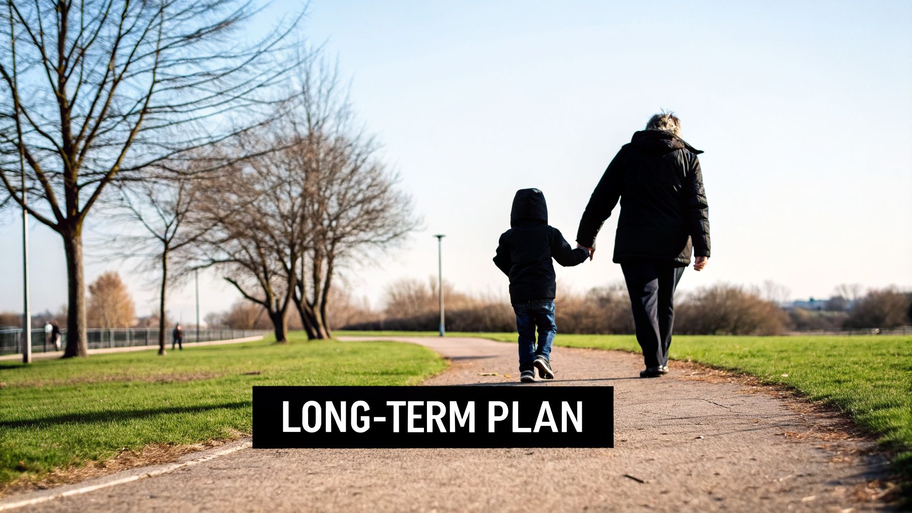 An adult and child walk hand-in-hand on a park path under a bright sky, symbolizing a long-term plan.