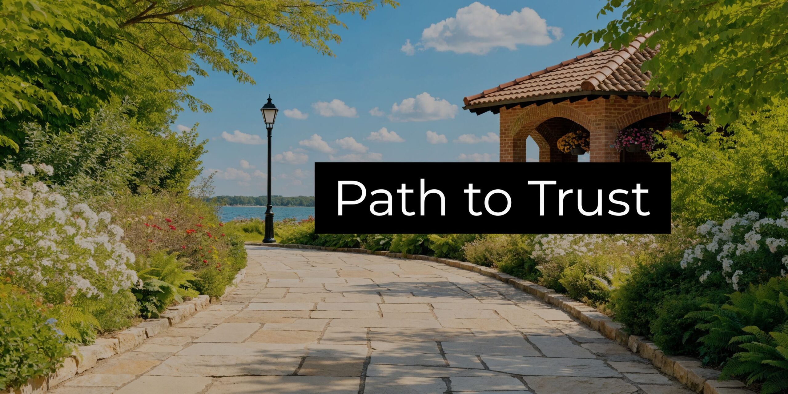 A peaceful stone walkway lined with flowers leads toward a lakeside pavilion under a bright blue sky.