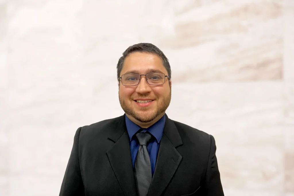 Alexander Beltaifa, Associate Attorney at Law Office of Bryan Fagan, smiling in professional attire against a neutral background.