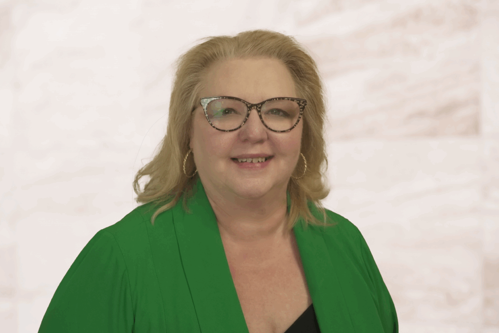 Deborah Coleman, family law attorney, smiling in a green blazer, professional headshot, showcasing expertise and approachability in legal matters.