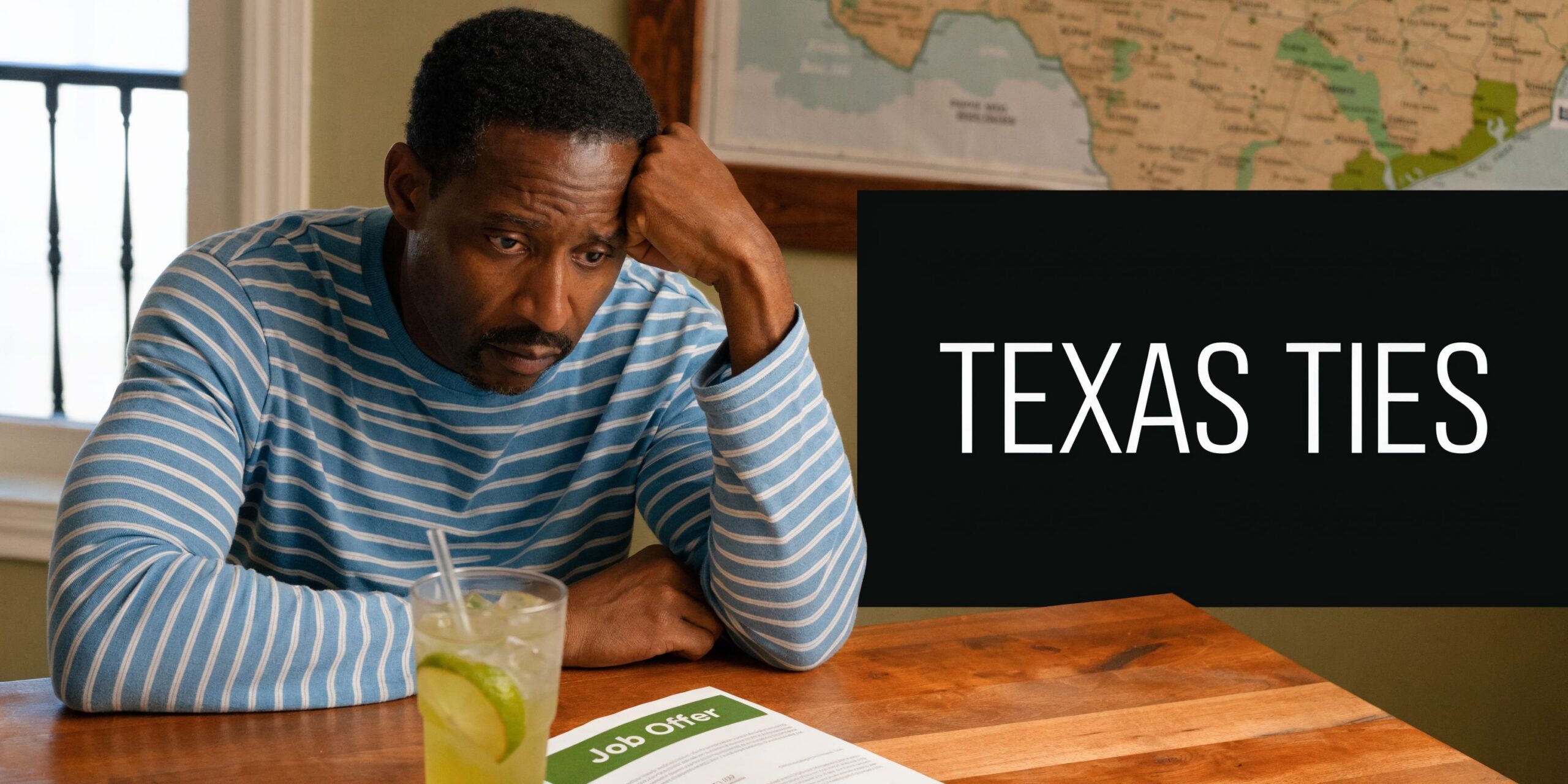 A pensive man in a striped shirt sitting at a table looking at a job offer letter.