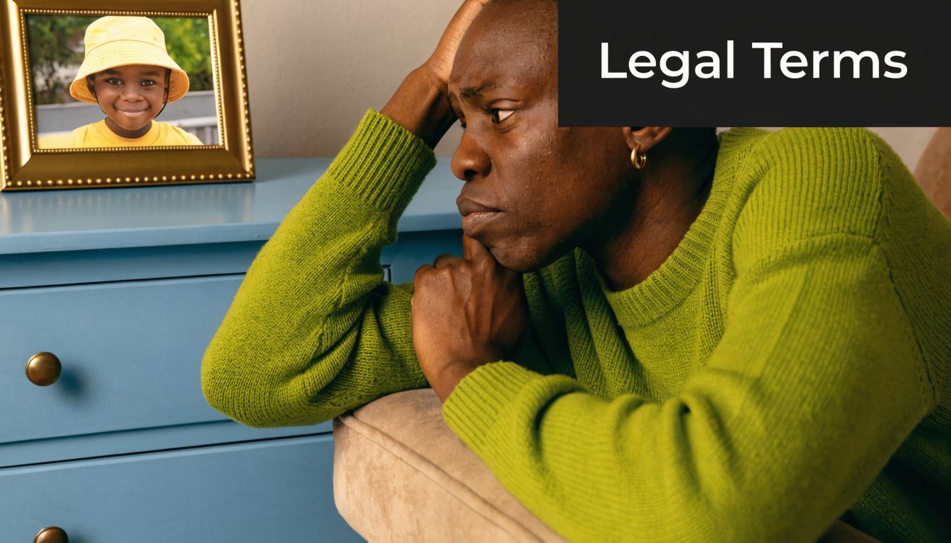 A man wearing a green sweater looks sad while sitting near a framed photo of a child.